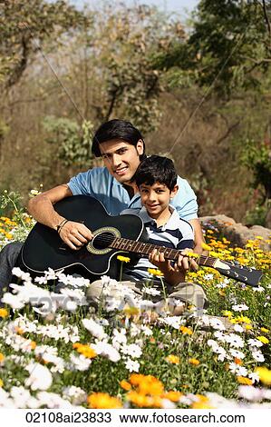 Father and son with guitar in park View Large Photo Image Stock Image - Father and son with guitar in park. Fotosearch