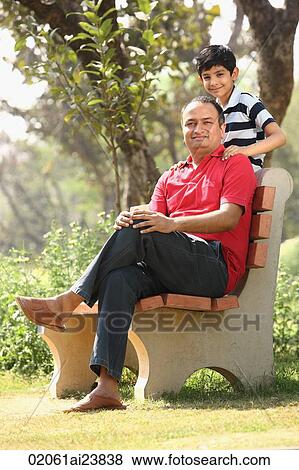 Father on bench, son standing View Large Photo Image Stock Photo - Father on bench, son standing. Fotosearch
