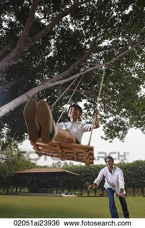 father pushing son in swing View Large Photo Image Stock Photograph - father pushing son in swing. Fotosearch