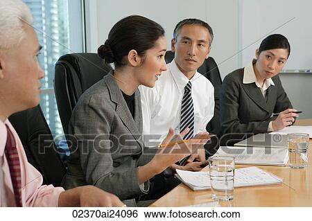 Stock Photograph - four colleagues at meeting. Fotosearch