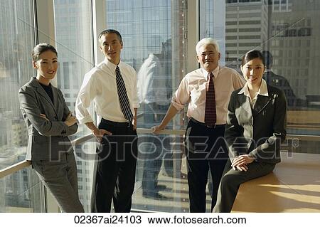 Stock Image - four colleagues in corner office. Fotosearch
