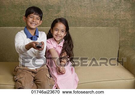 girl and boy on couch with tv remote View Large Photo Image Stock Image - girl and boy on couch with tv remote. Fotosearch
