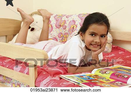 Girl in bed with book View Large Photo Image Stock Image - Girl in bed with book. Fotosearch
