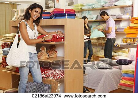 girl in store, couple in background View Large Photo Image Picture - girl in store, couple in background. Fotosearch