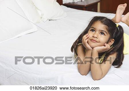 Girl lying on bed, resting on elbows View Large Photo Image Stock Image - Girl lying on bed, resting on elbows. Fotosearch