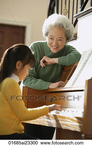 Girl playing piano for grandmother View Large Photo Image Stock Image - Girl playing piano for grandmother. Fotosearch