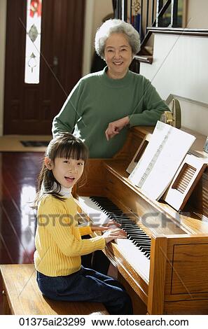 Girl playing piano for grandmother View Large Photo Image Stock Photo - Girl playing piano for grandmother. Fotosearch