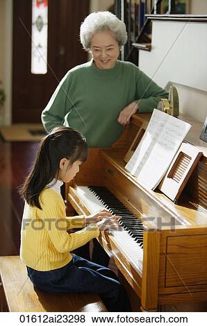 Girl playing piano for grandmother View Large Photo Image Stock Photo - Girl playing piano for grandmother. Fotosearch