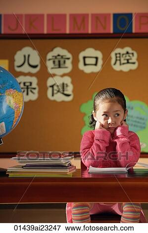 Stock Photo - Girl sitting in class, looking away from camera. Fotosearch