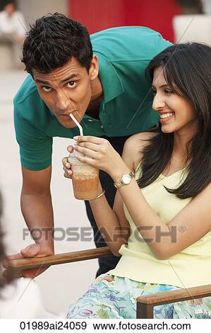Stock Photo - girlfriend sharing drink with boyfriend. Fotosearch