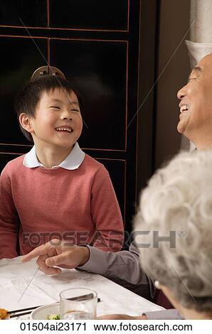 Grandfather and son laughing at dinner table View Large Photo Image Stock Image - Grandfather and son laughing at dinner table. Fotosearch