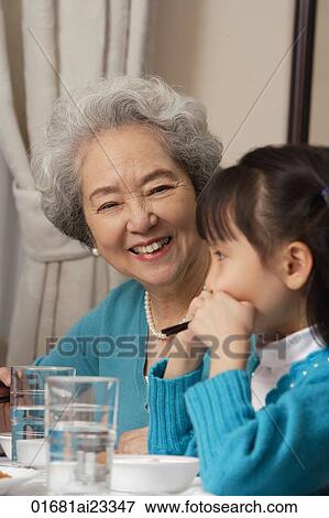 Grandmother and grandchild at dinner table View Large Photo Image Stock Photo - Grandmother and grandchild at dinner table. Fotosearch