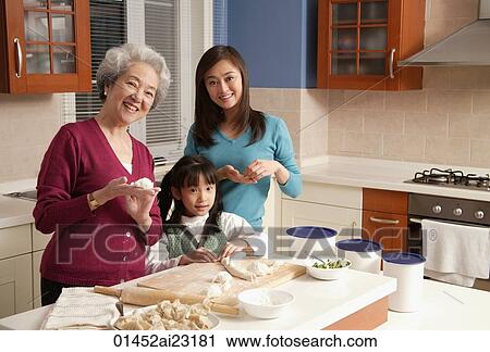 Grandmother, daughter and granddaughter making dumplings in the kitchen, looking at camera View Large Photo Image Stock Image - Grandmother, daughter and granddaughter making dumplings in the kitchen, looking at camera. Fotosearch