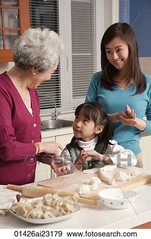 Grandmother, daughter and granddaughter making dumplings in the kitchen View Large Photo Image Stock Photo - Grandmother, daughter and granddaughter making dumplings in the kitchen. Fotosearch