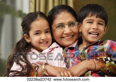 Stock Image - grandmother hugs grandkids, all smile at camera. Fotosearch