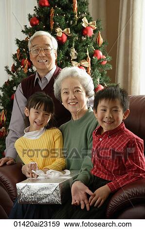 Grandparents with grandchildren at Christmas time smiling at camera View Large Photo Image Stock Photo - Grandparents with grandchildren at Christmas time smiling at camera. Fotosearch