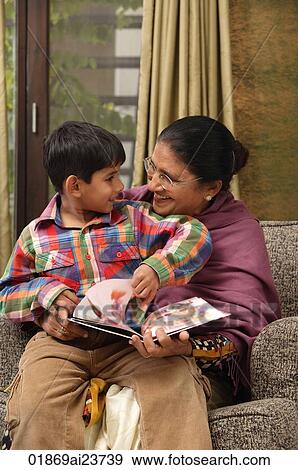 Stock Photo - grandson sits on grandmothers lap for story. Fotosearch