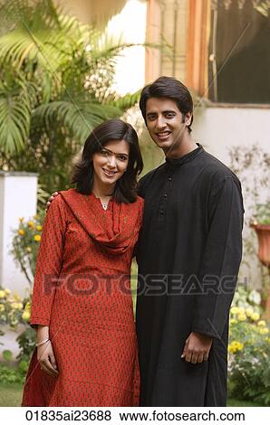 Stock Photo - husband and wife standing for portrait in garden, smiling at camera. Fotosearch