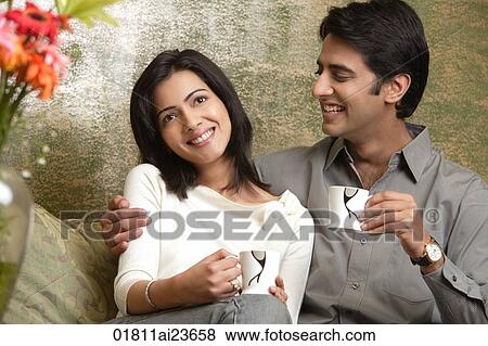 Stock Photo - laughing couple holding tea cups. Fotosearch
