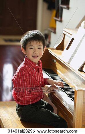 Stock Photography - Little boy playing piano. Fotosearch
