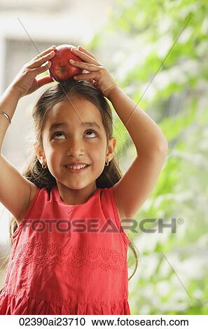little girl holding apple on her head View Large Photo Image Stock Image - little girl holding apple on her head. Fotosearch