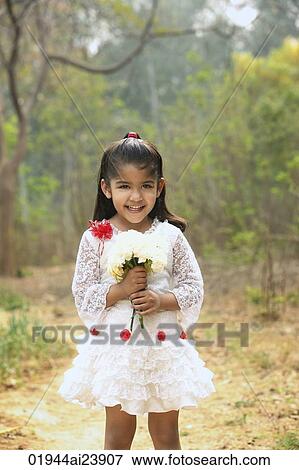 Little girl in white dress holding bouquet (vertical) View Large Photo Image Stock Photo - Little girl in white dress holding bouquet (vertical). Fotosearch