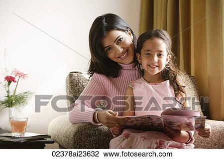 little girl sits on mother's lap, both smile at camera View Large Photo Image Stock Image - little girl sits on mother's lap, both smile at camera. Fotosearch