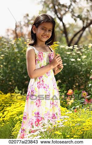 Little girl standing with yellow flowers View Large Photo Image Stock Image - Little girl standing with yellow flowers. Fotosearch