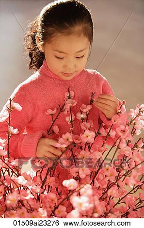 Stock Photograph - Little girl with cherry blossom branches. Fotosearch