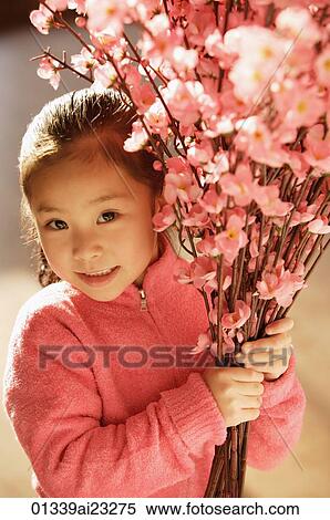 Stock Photography - Little girl with cherry blossom branches. Fotosearch