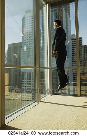 Stock Image - man jumping in corner of office. Fotosearch