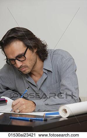 Stock Image - Man sitting at desk drawing. Fotosearch