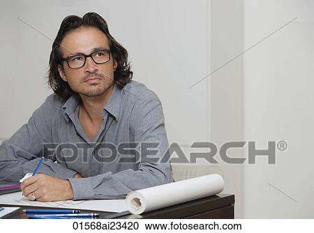Man sitting at with pencil in hand looking up View Large Photo Image Stock Image - Man sitting at with pencil in hand looking up. Fotosearch
