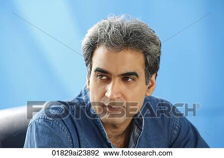 Stock Image - Man with gray hair, blue background (horizontal). Fotosearch