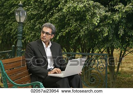 man with laptop on bench View Large Photo Image Picture - man with laptop on bench. Fotosearch