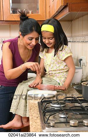 Picture - Mom and daughter making bread. Fotosearch