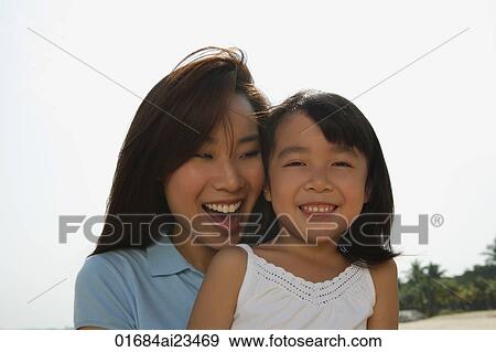 Mother and daughter smiling at the beach View Large Photo Image Stock Photo - Mother and daughter smiling at the beach. Fotosearch