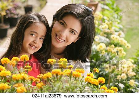 Stock Photo - mother and daughter with flowers, smiling at camera. Fotosearch