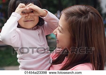 Mother carrying young daughter View Large Photo Image Stock Photo - Mother carrying young daughter. Fotosearch