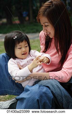 Mother on the ground with young daughter sitting on lap View Large Photo Image Stock Photo - Mother on the ground with young daughter sitting on lap. Fotosearch