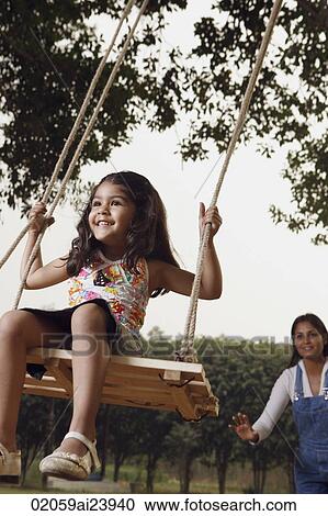 mother pushing girl on swing View Large Photo Image Stock Image - mother pushing girl on swing. Fotosearch