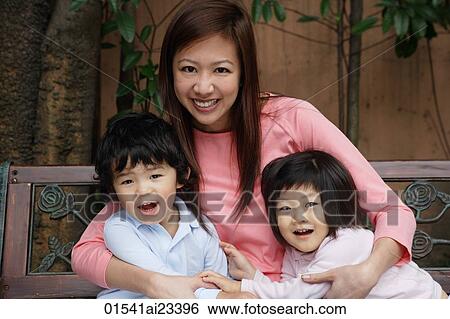 Stock Photograph - Mother sitting hugging young children. Fotosearch