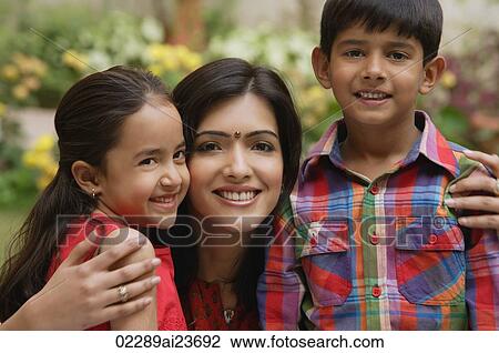 Stock Image - mother with arms around son and daughter, all smiling at camera. Fotosearch