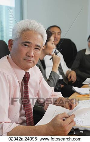 Stock Photography - older businessman with colleagues at meeting. Fotosearch