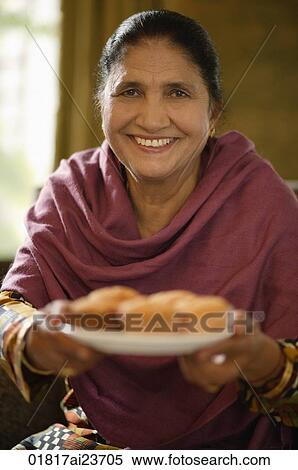 older woman offering food, smiling at camera View Large Photo Image Stock Photography - older woman offering food, smiling at camera. Fotosearch