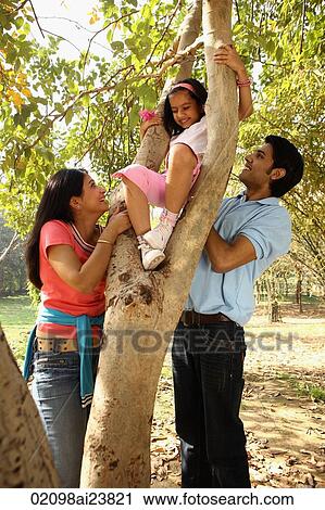 Parents helping daugther climb a tree View Large Photo Image Stock Image - Parents helping daugther climb a tree. Fotosearch