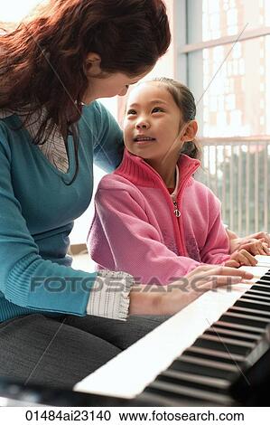 Piano teacher and girl playing piano View Large Photo Image Stock Image - Piano teacher and girl playing piano. Fotosearch