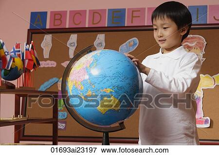 Schoolboy looking at globe View Large Photo Image Stock Photo - Schoolboy looking at globe. Fotosearch