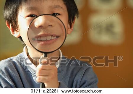 Stock Image - Schoolboy with magnifying glass. Fotosearch