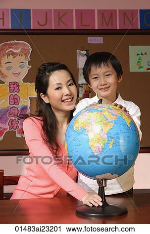 Stock Image - Schoolboy with teacher and globe. Fotosearch